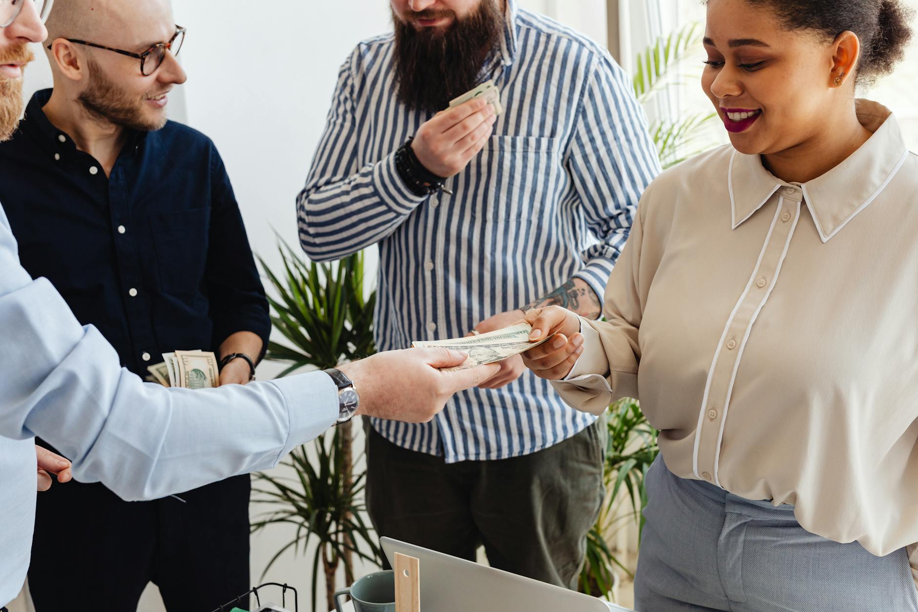 Menedżerowie przekazują sobie gotówkę w biurze podczas rozmowy