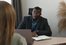 Kultura feedbacku w organizacji: 5 błędów, przez które pracownicy unikają szczerości Mężczyzna prowadzący formalną rozmowę w nowoczesnym biurze